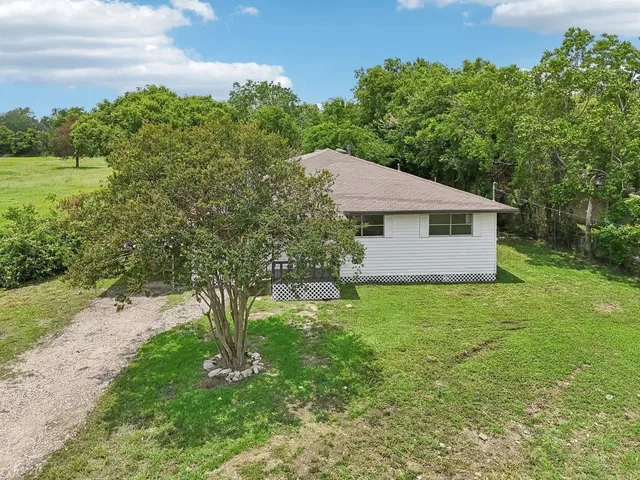 a aerial view of a house next to a yard and large tree