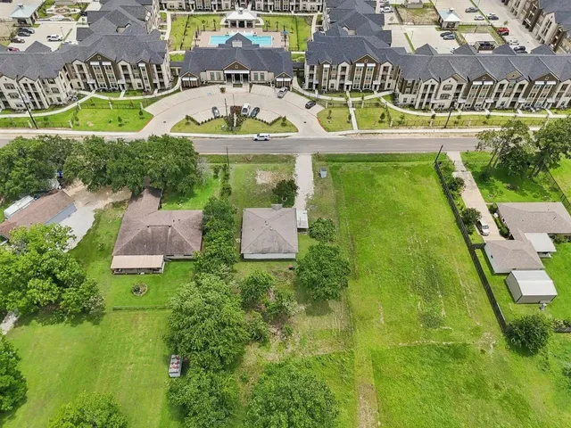 an aerial view of residential houses with outdoor space and swimming pool