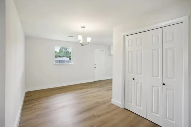 an empty room with wooden floor and window