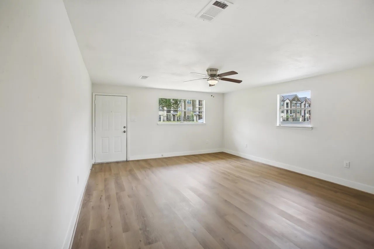 906 S Road Baytown, TX 77521 - Photo 5 of 32 an empty room with wooden floor and windows