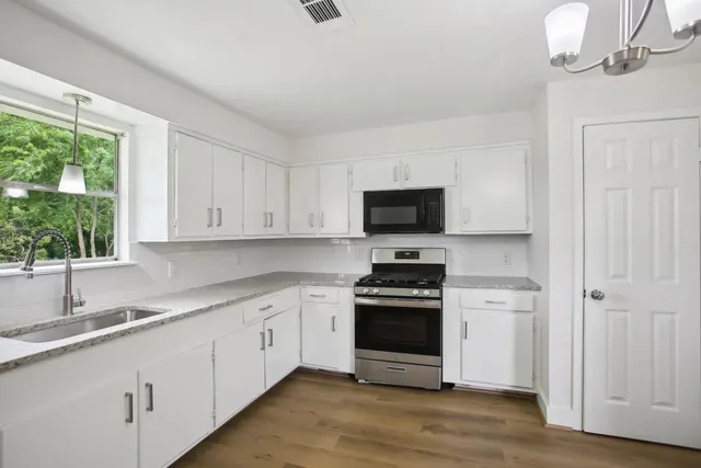 a kitchen with stainless steel appliances white cabinets and a sink