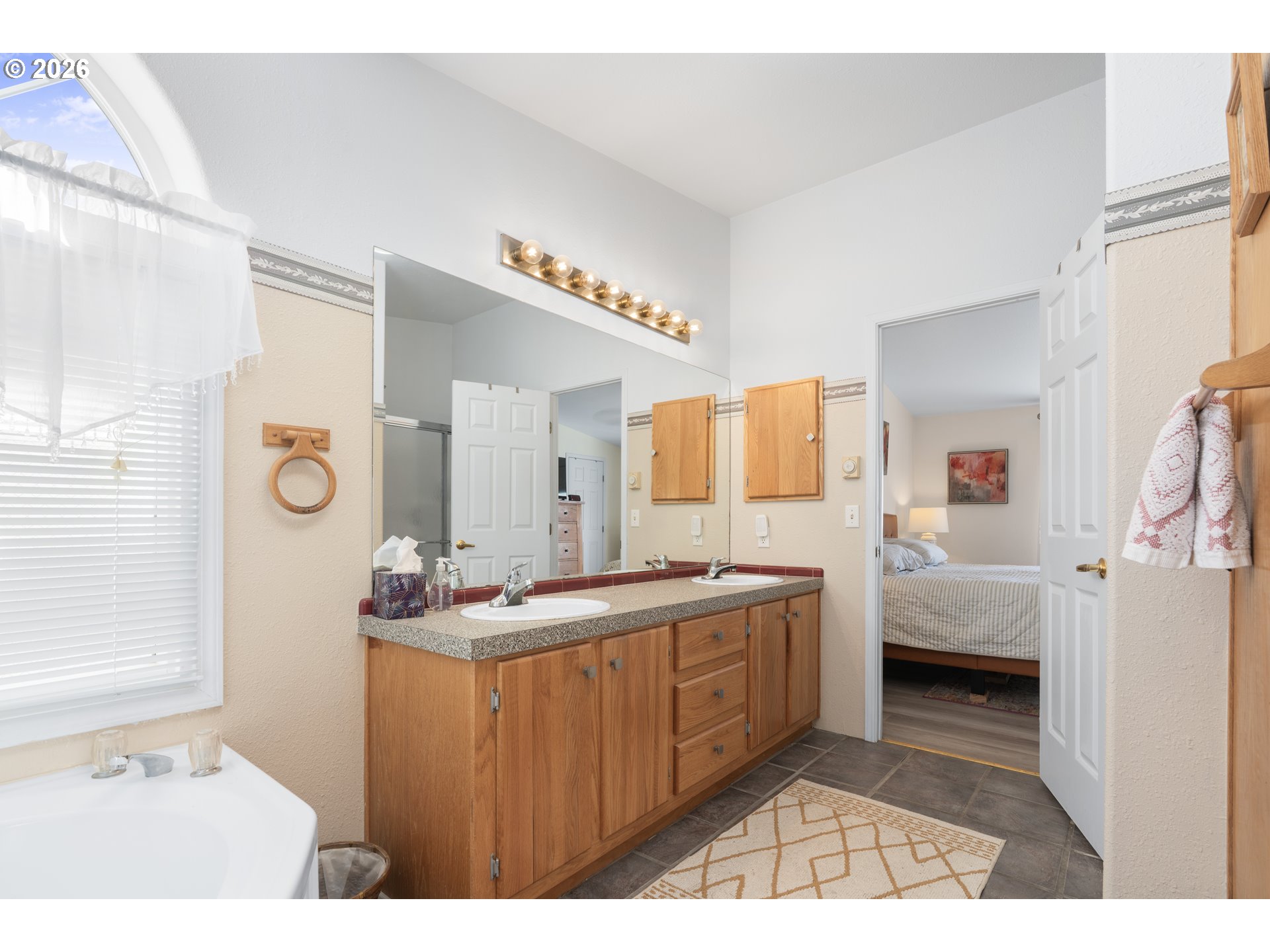 94033 Doyle Point Road Gold Beach, OR 97444 - Photo 25 of 42 a en suite bathroom with a double vanity sink a mirror and a bathtub