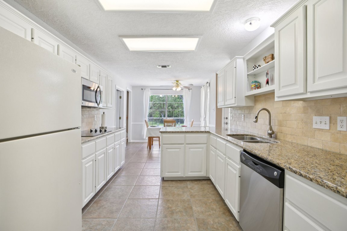 148 Oak Ridge Drive Cedar Creek, TX 78612 - Photo 17 of 40 a kitchen with white cabinets and white appliances
