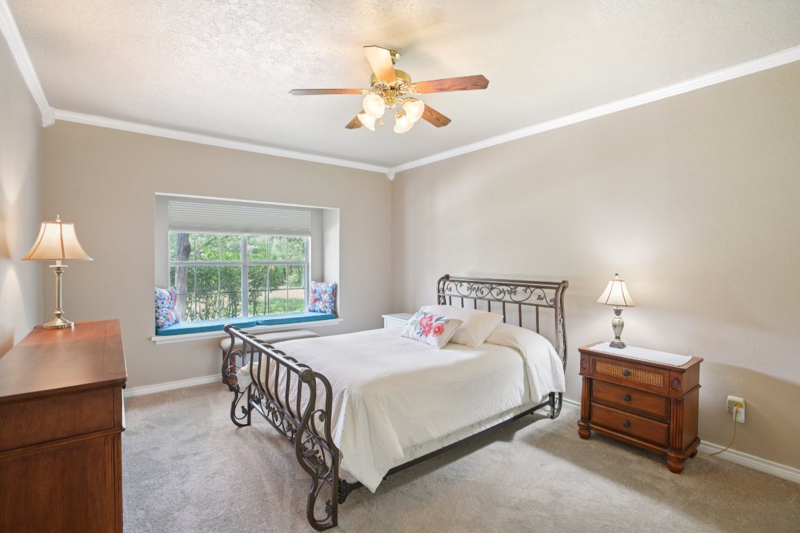 148 Oak Ridge Drive Cedar Creek, TX 78612 - Photo 25 of 40 a bedroom with a bed and a chandelier