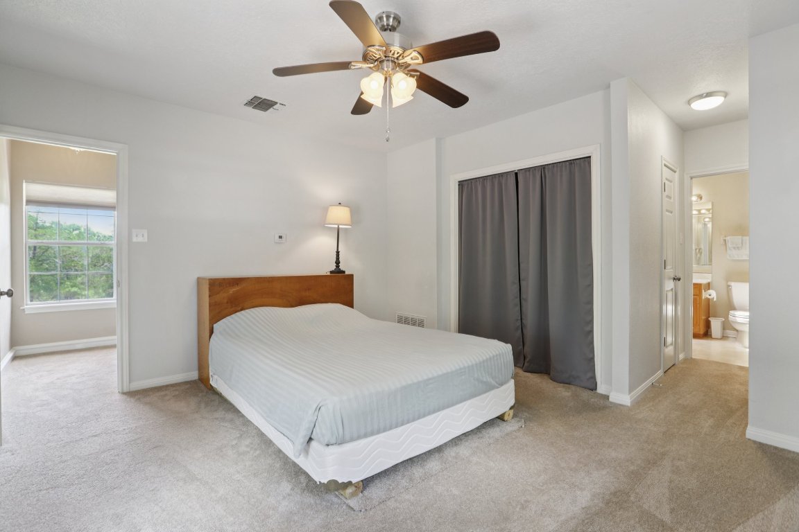148 Oak Ridge Drive Cedar Creek, TX 78612 - Photo 29 of 40 a spacious bedroom with a bed and a chandelier