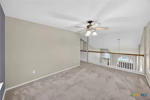 an empty room with chandelier fan