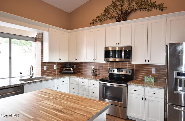 a kitchen with stainless steel appliances granite countertop a stove a sink and a microwave