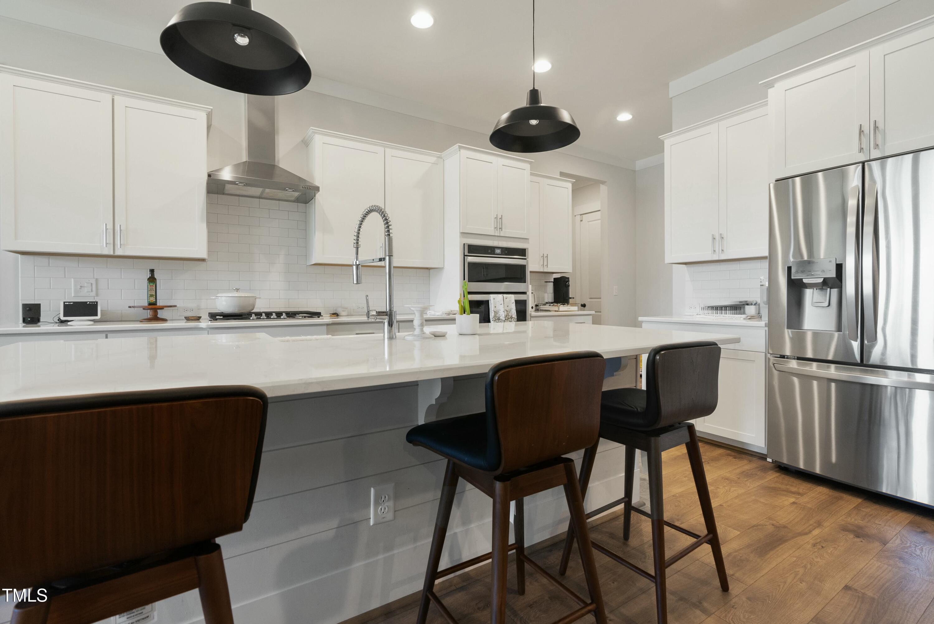 512 Adkins Ridge Road Rolesville, NC 27571 - Photo 15 of 53 a kitchen with stainless steel appliances a table chairs refrigerator and cabinets
