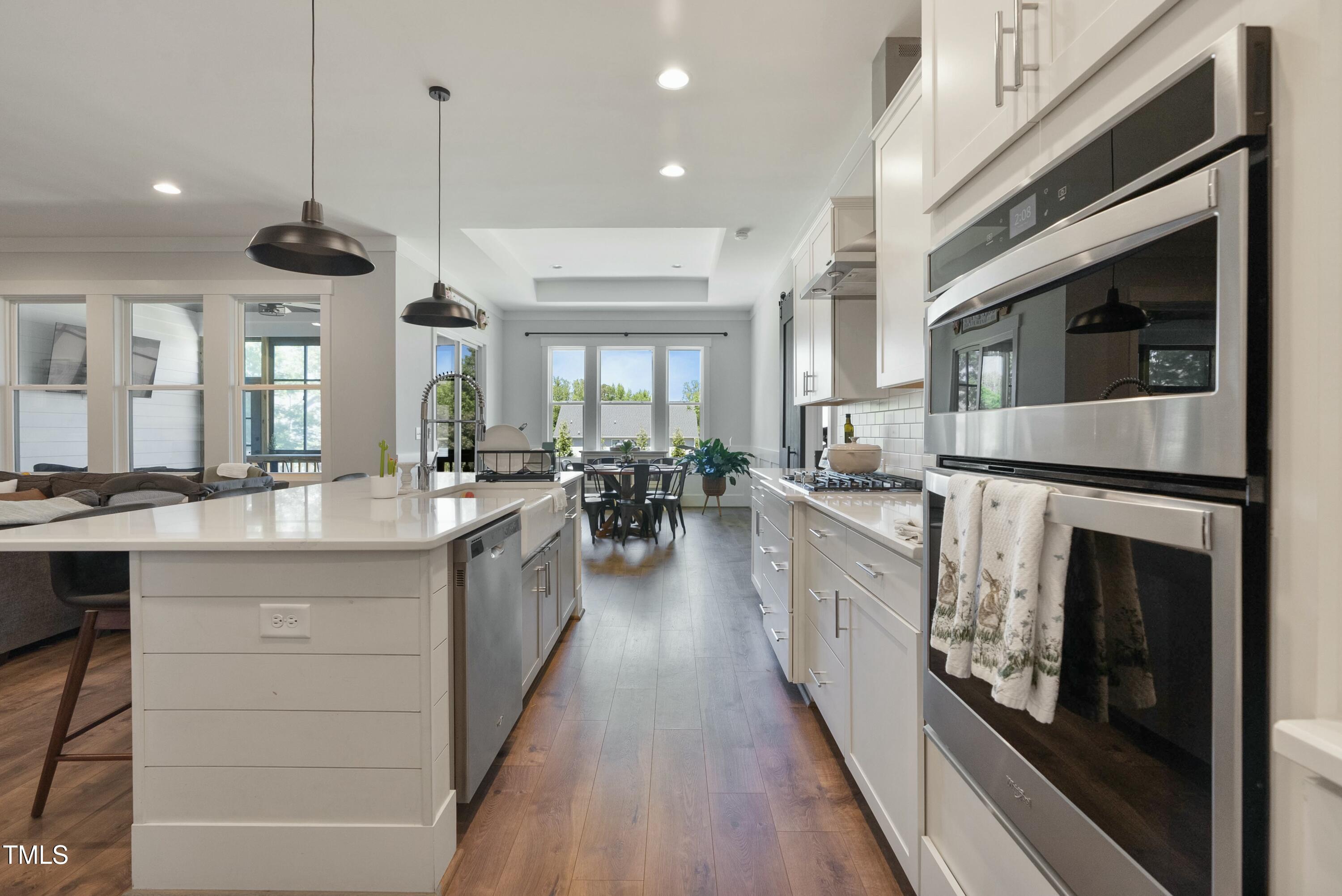 512 Adkins Ridge Road Rolesville, NC 27571 - Photo 16 of 53 a large white kitchen with a large window a sink and stainless steel appliances