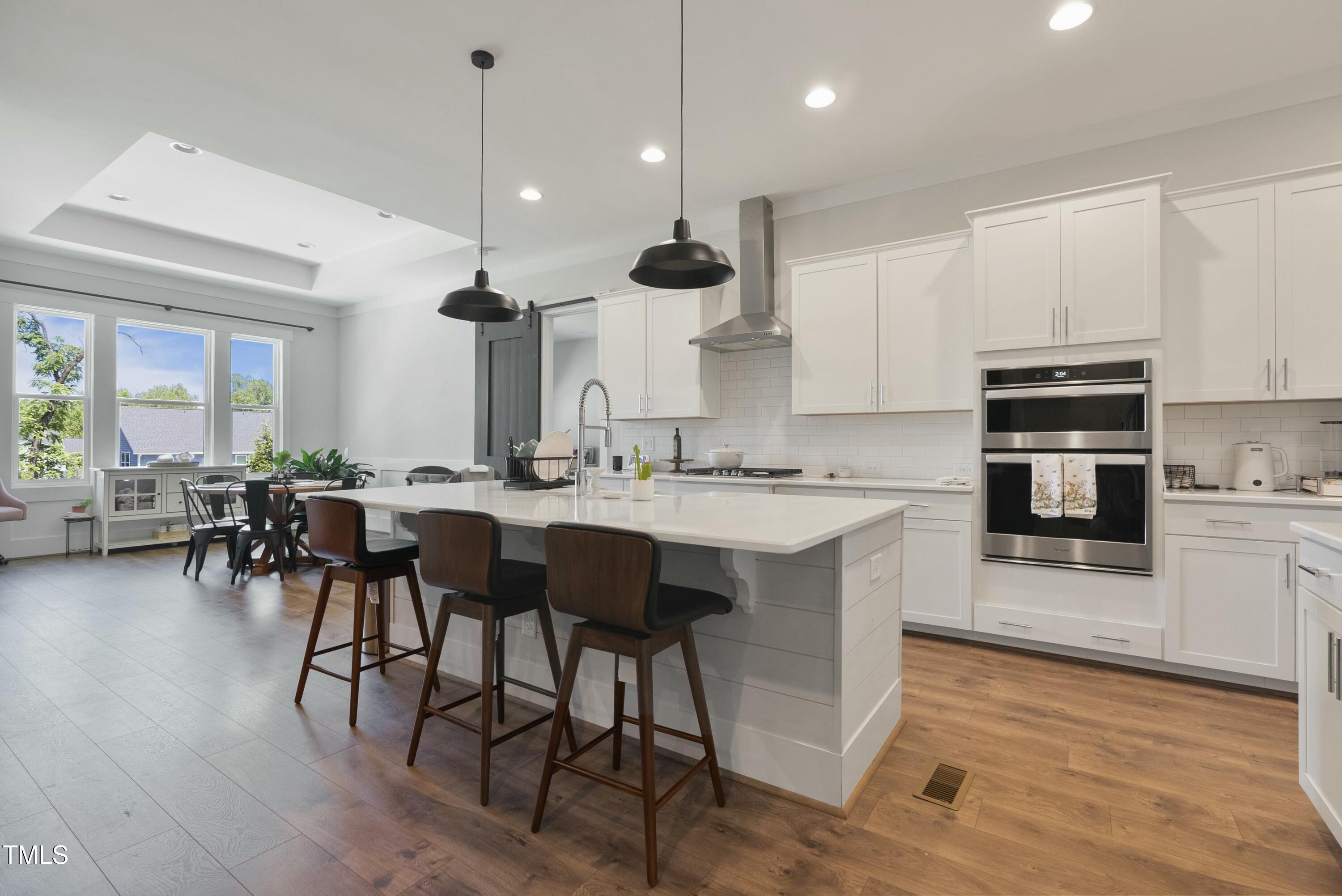 512 Adkins Ridge Road Rolesville, NC 27571 - Photo 18 of 53 a kitchen with stainless steel appliances granite countertop wooden floors and white cabinets