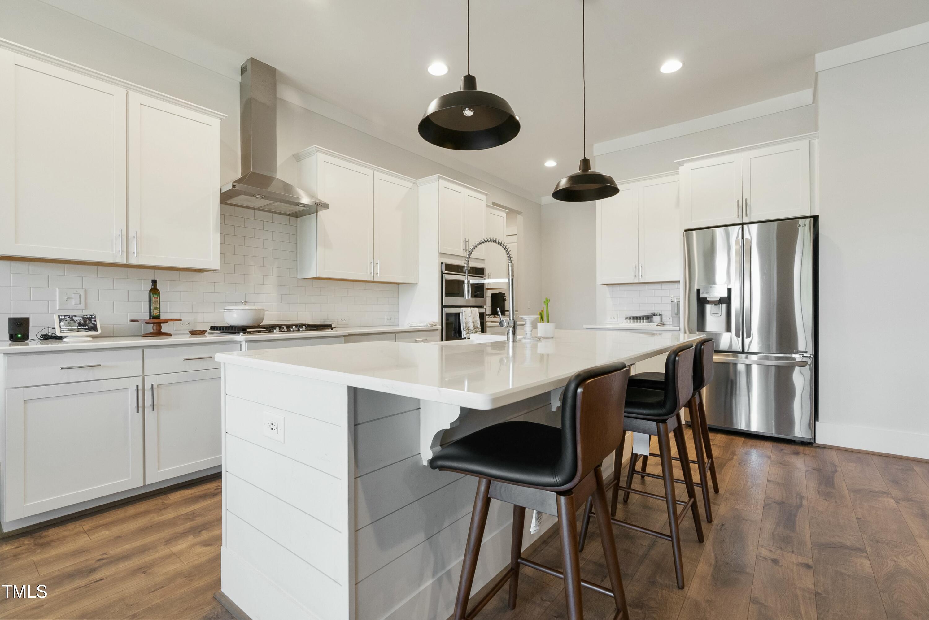 512 Adkins Ridge Road Rolesville, NC 27571 - Photo 19 of 53 a kitchen with stainless steel appliances a dining table chairs sink and microwave