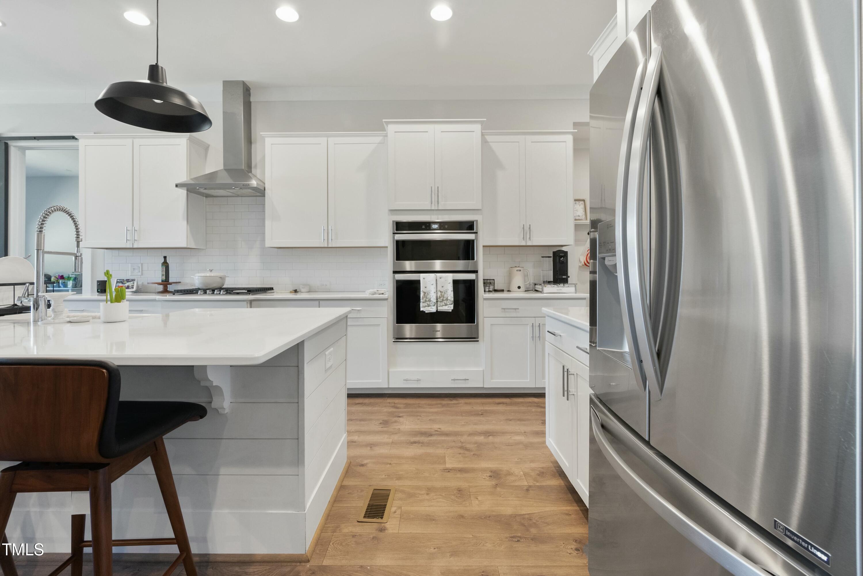 512 Adkins Ridge Road Rolesville, NC 27571 - Photo 20 of 53 a kitchen with stainless steel appliances a refrigerator a sink a stove and white cabinets