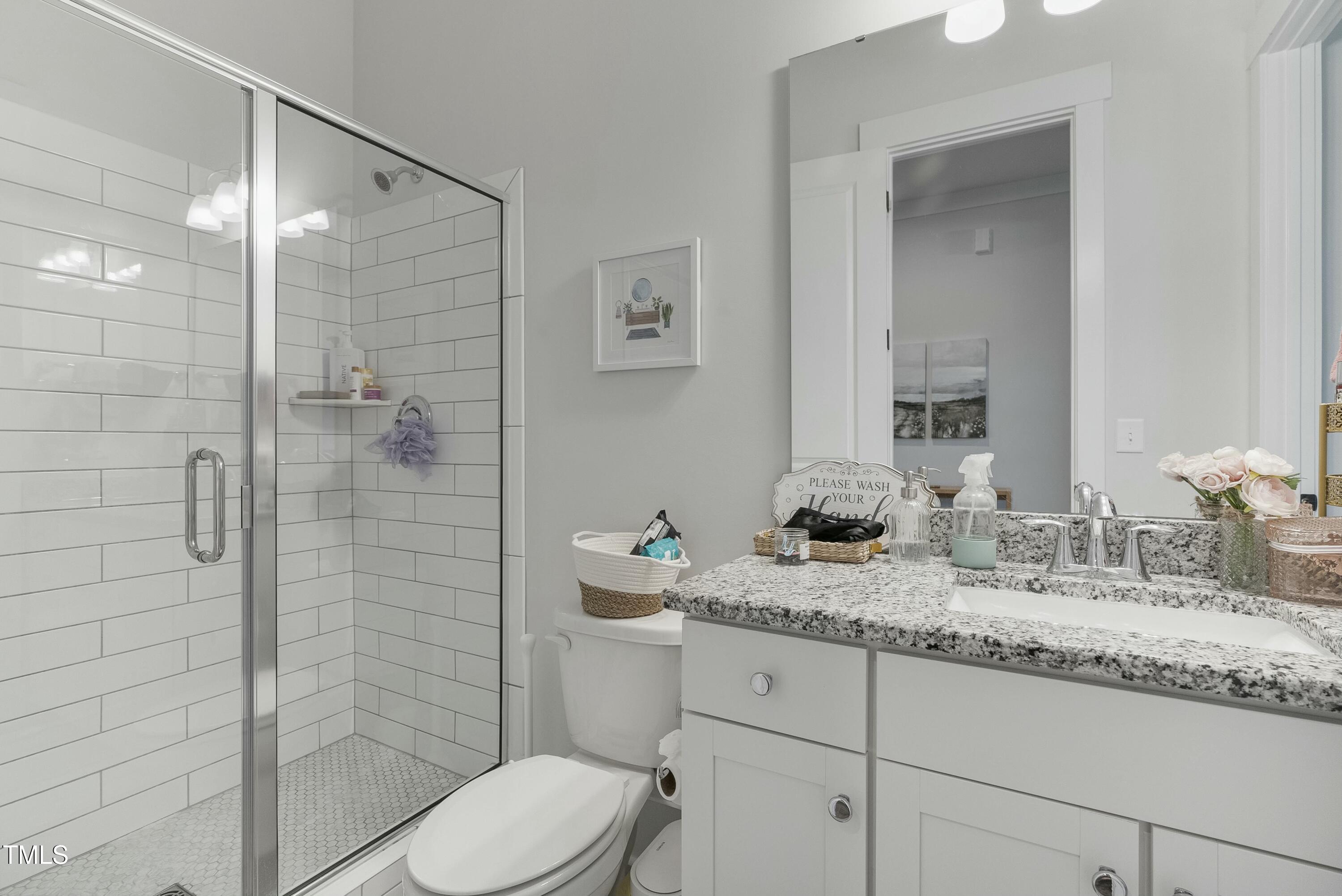 512 Adkins Ridge Road Rolesville, NC 27571 - Photo 38 of 53 a bathroom with a granite countertop sink mirror and toilet