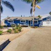 a view of a building with a yard and palm trees
