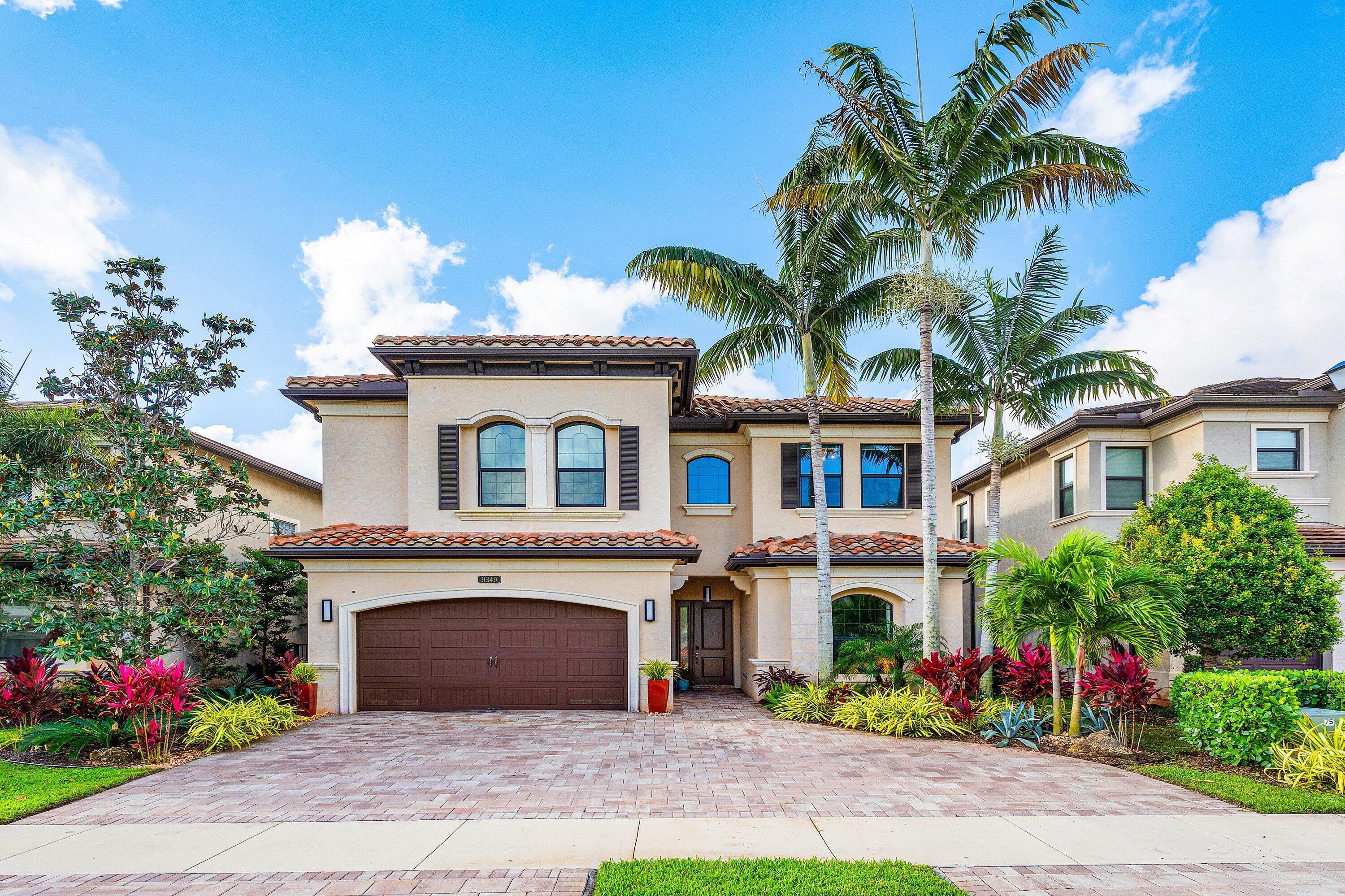 9349 Eden Roc Court Delray Beach, FL 33446 - Photo 1 of 50 a front view of a house with a garden