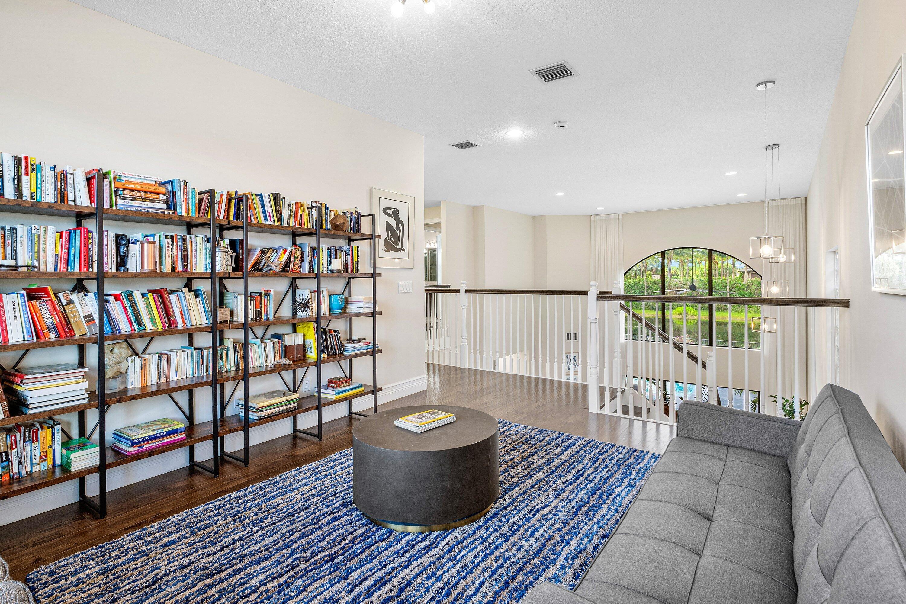 9349 Eden Roc Court Delray Beach, FL 33446 - Photo 15 of 50 a living room with furniture a rug and a book shelf