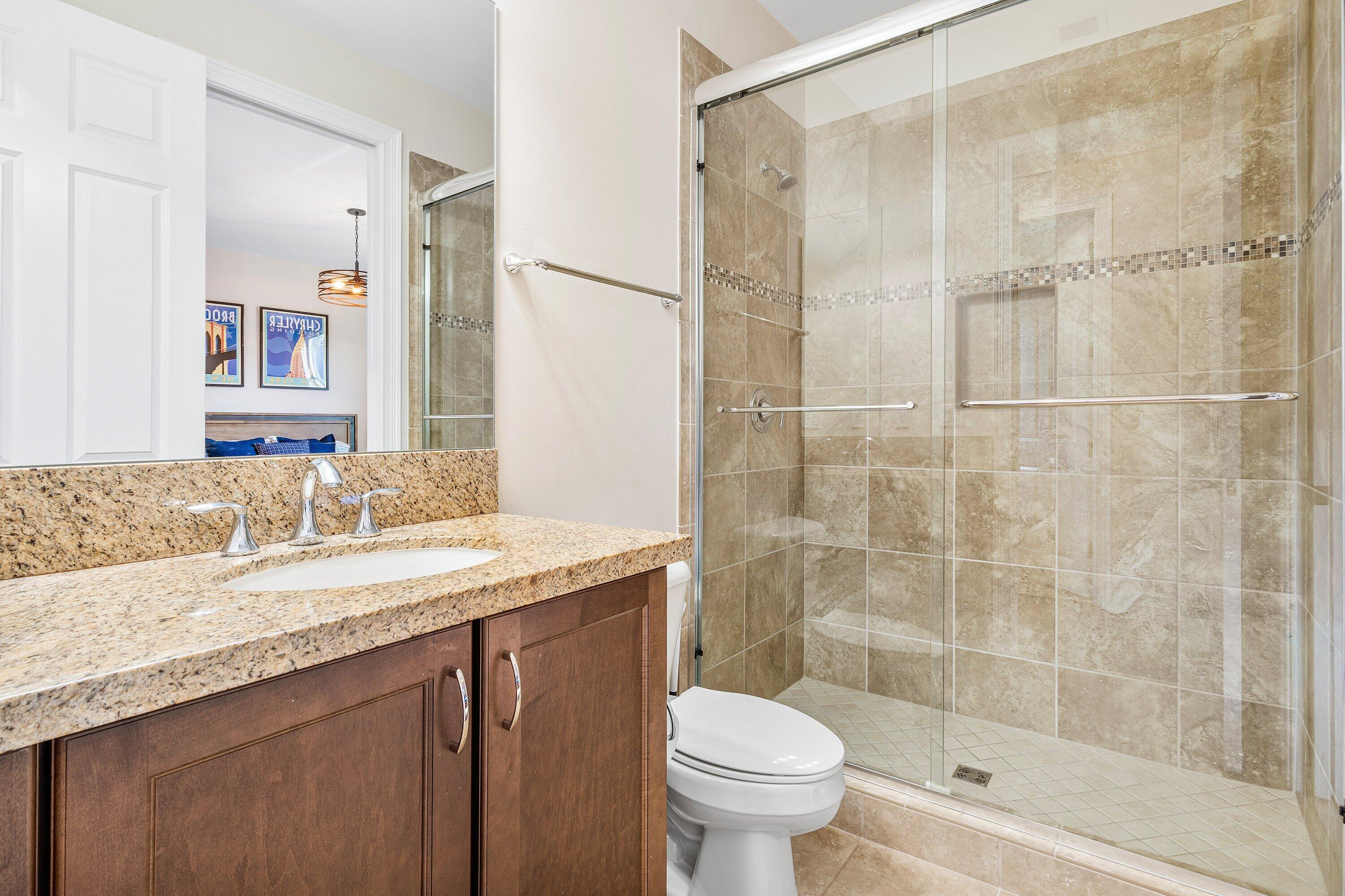9349 Eden Roc Court Delray Beach, FL 33446 - Photo 20 of 50 a bathroom with a granite countertop sink a toilet and shower