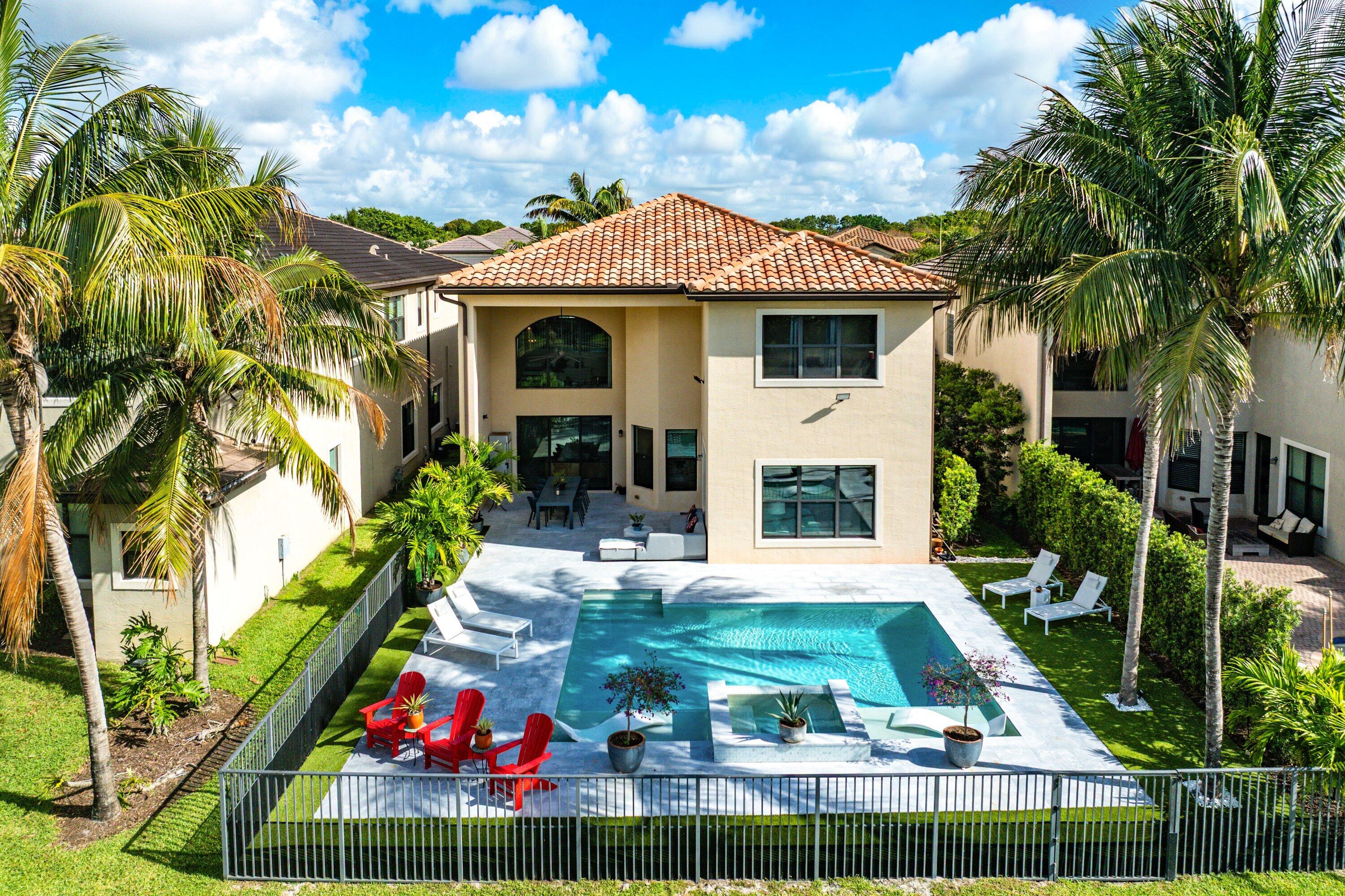 9349 Eden Roc Court Delray Beach, FL 33446 - Photo 27 of 50 a view of a white house with a yard table and chairs