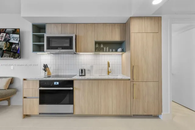 a kitchen with stainless steel appliances a refrigerator sink and microwave
