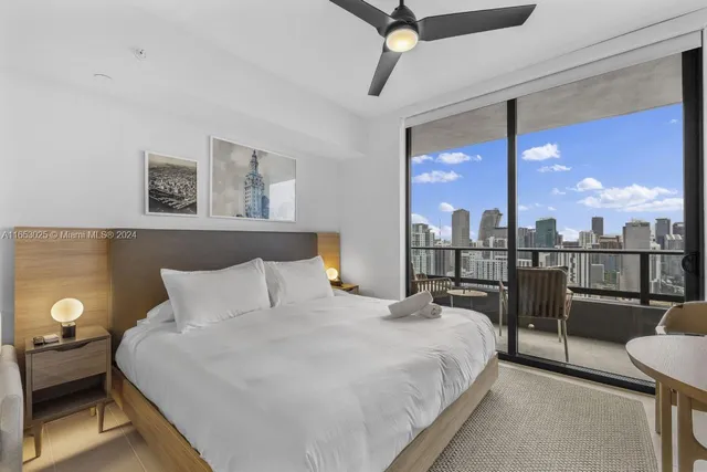 a bedroom with a balcony a bed and a chandelier