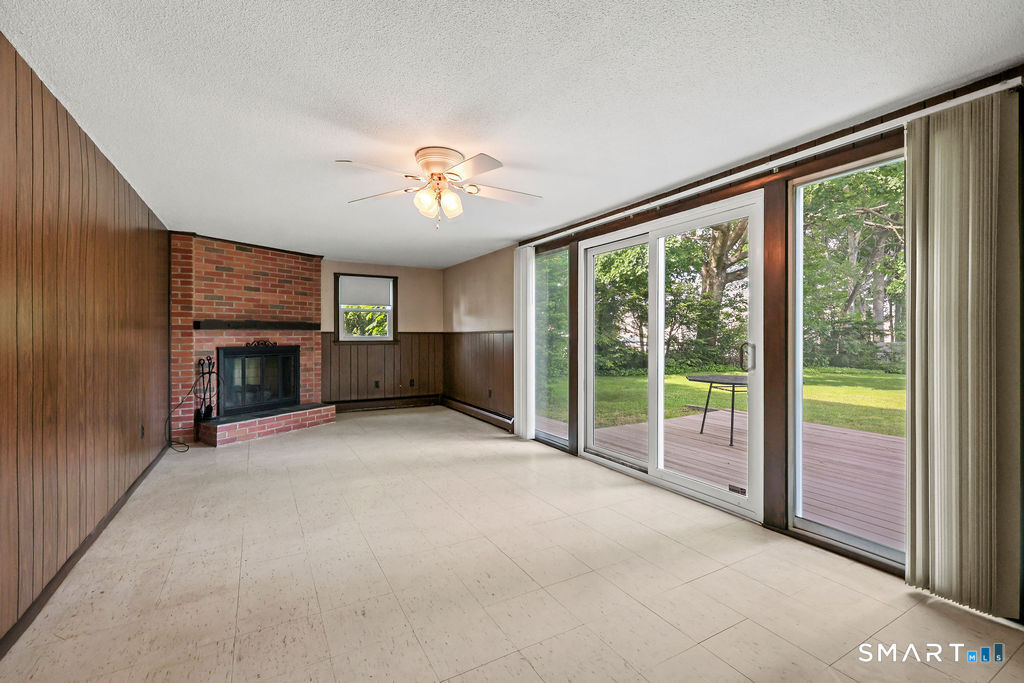 142 Wolcott Hill Road Wethersfield, CT 06109 - Photo 20 of 29 a view of an empty room with a fireplace and a large window