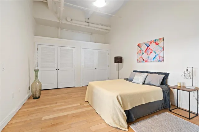 a bedroom with a bed and a painting on the wall