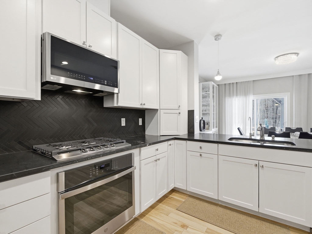 4 Wilshire Lane Pelham, NH 03076 - Photo 11 of 42 a kitchen with granite countertop a sink a stove and cabinets