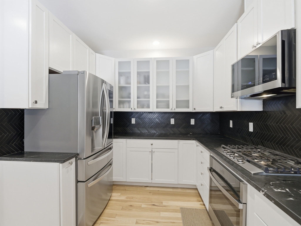 4 Wilshire Lane Pelham, NH 03076 - Photo 14 of 42 a kitchen with granite countertop a refrigerator and a stove top oven