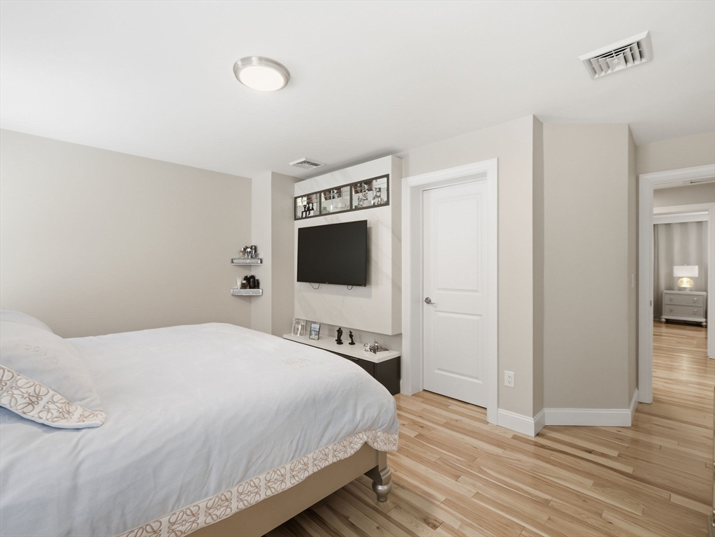 4 Wilshire Lane Pelham, NH 03076 - Photo 18 of 42 a bedroom with a bed and wooden floor