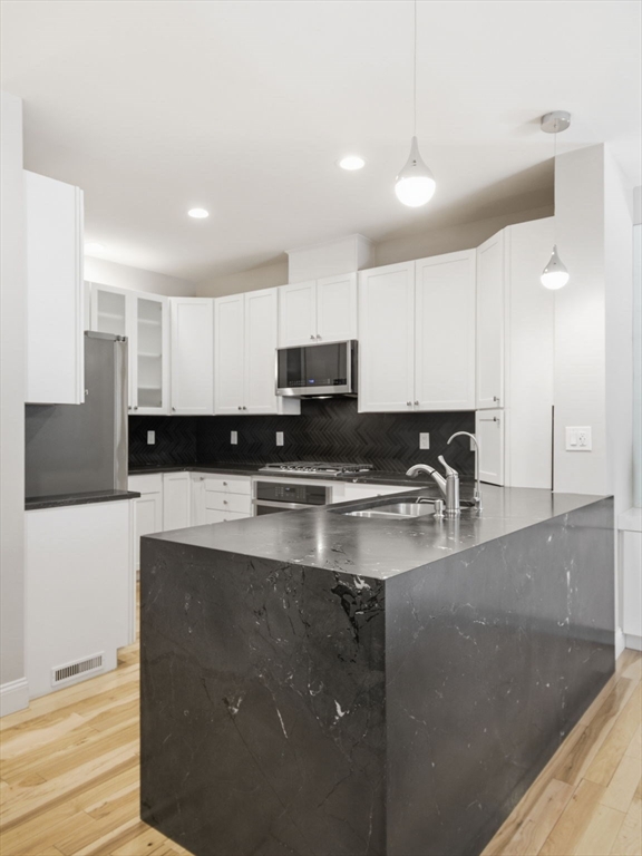 4 Wilshire Lane Pelham, NH 03076 - Photo 9 of 42 a kitchen with stainless steel appliances granite countertop a sink a stove a refrigerator a microwave with white cabinets and a refrigerator