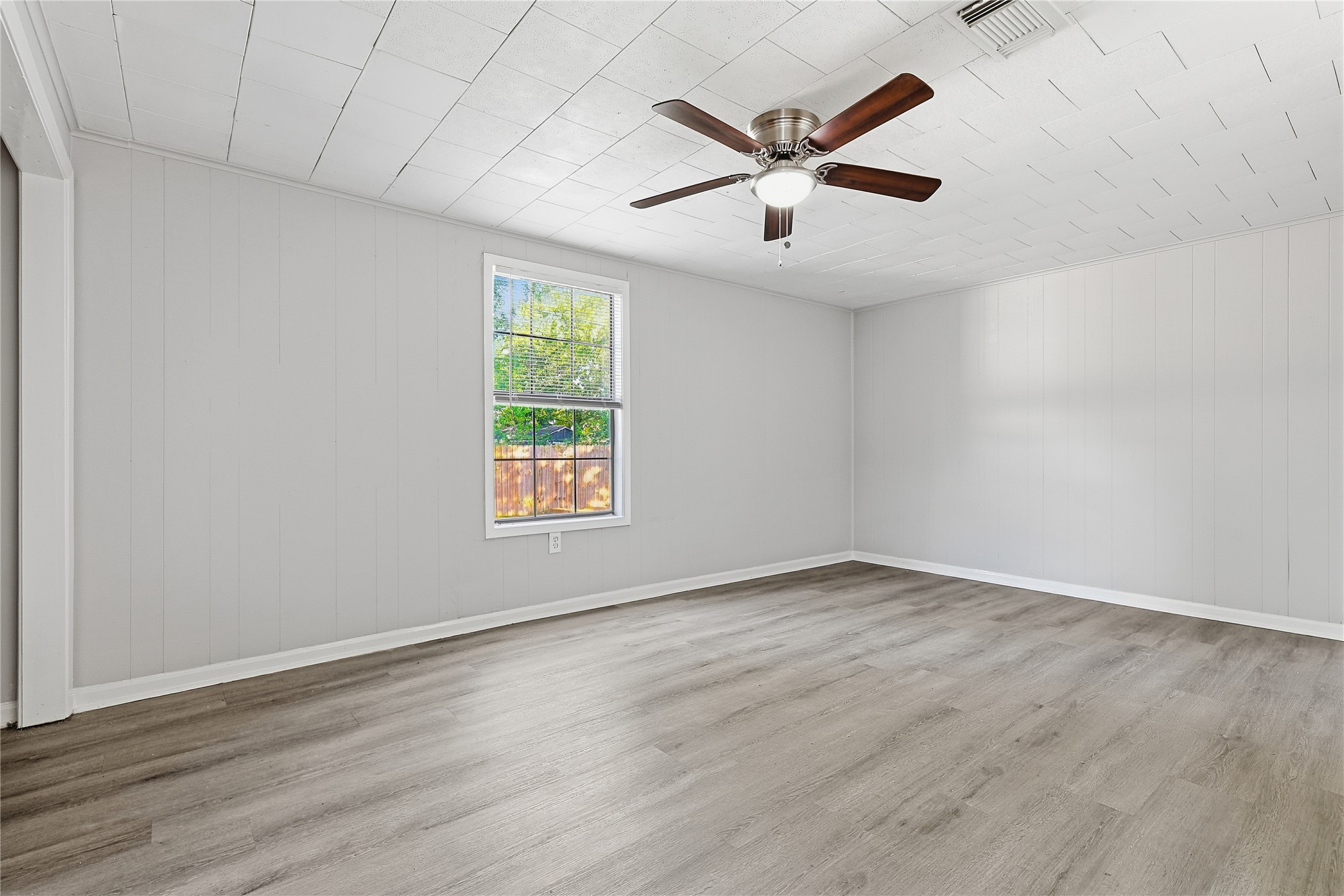 207 Farrer Street Angleton, TX 77515 - Photo 17 of 24 an empty room with wooden floor and windows