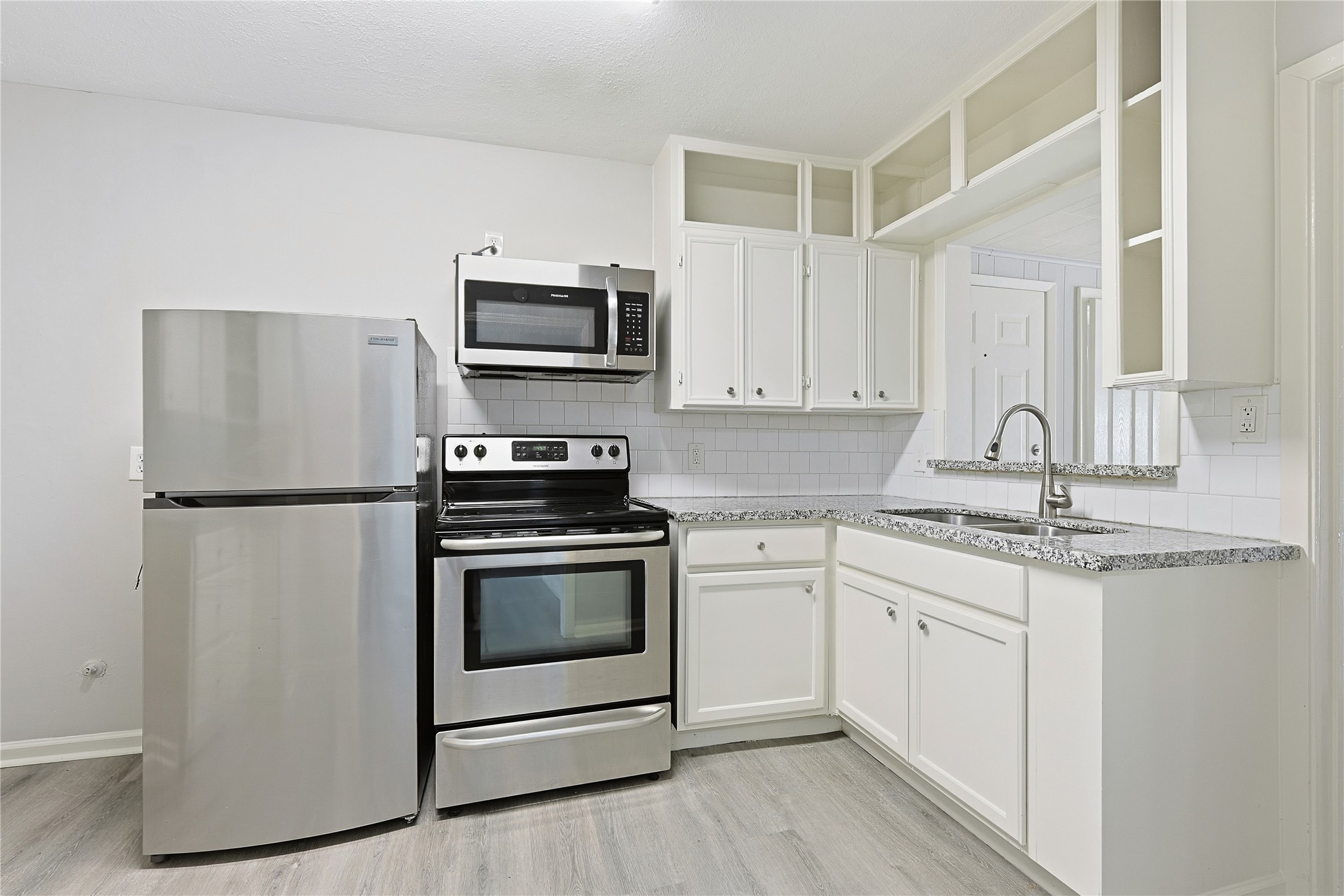 207 Farrer Street Angleton, TX 77515 - Photo 21 of 24 a kitchen with stainless steel appliances granite countertop a stove a sink and a refrigerator