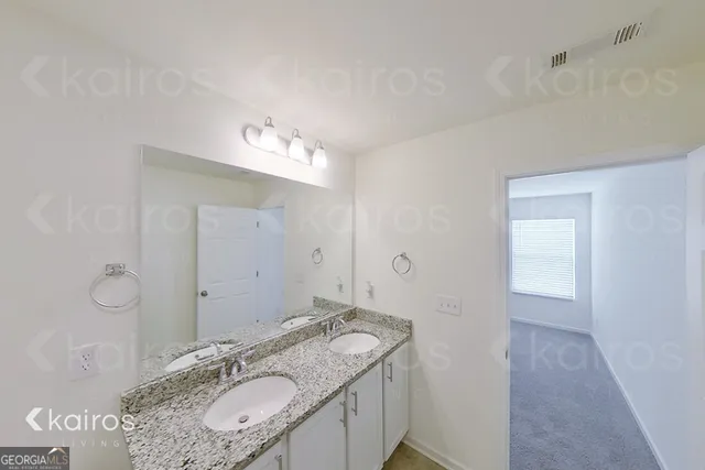 a spacious bathroom with a granite countertop sink a mirror and a vanity