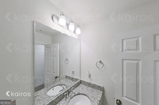 a spacious bathroom with a granite countertop sink a mirror and shower