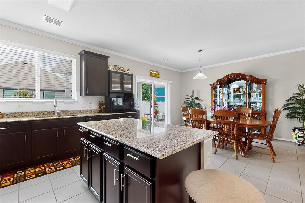 1712 Intervale Road Providence Village, TX 76227 - Photo 14 of 39 a kitchen with a stove a kitchen island a dining table and chairs