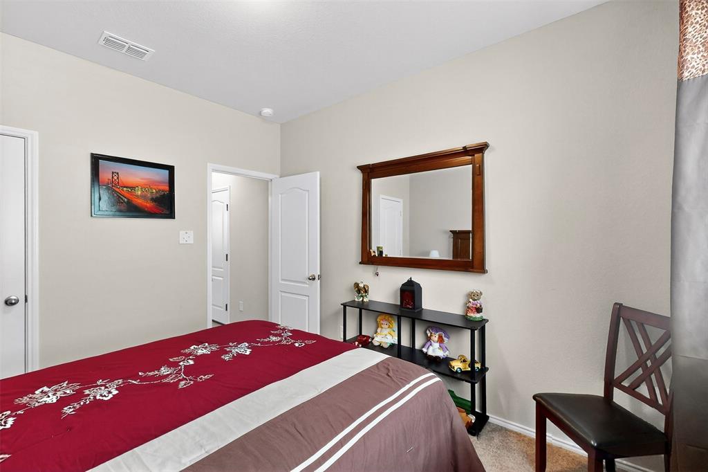 1712 Intervale Road Providence Village, TX 76227 - Photo 32 of 39 a bedroom with a bed and a bookshelf with a chair