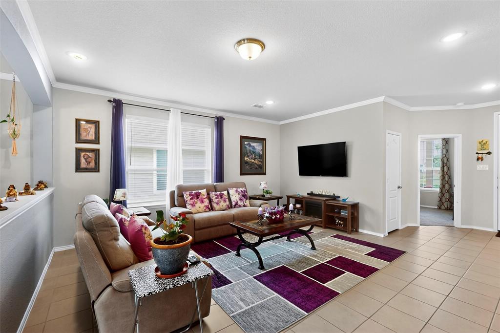 1712 Intervale Road Providence Village, TX 76227 - Photo 10 of 39 a living room with furniture a rug and a flat screen tv