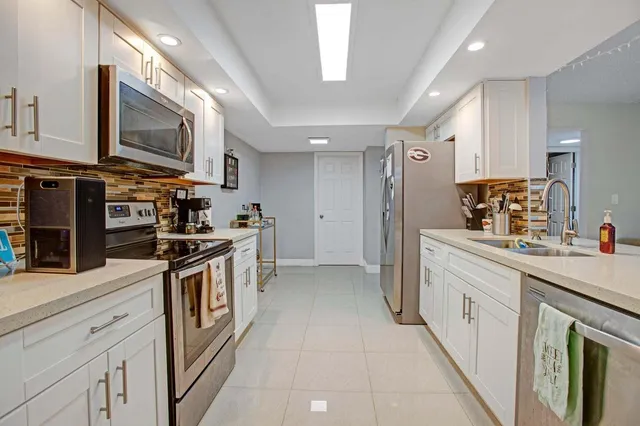 a kitchen with stainless steel appliances granite countertop a stove a sink and a refrigerator