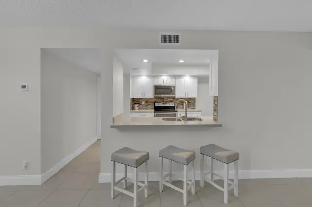 a view of kitchen with granite countertop cabinets table and chairs