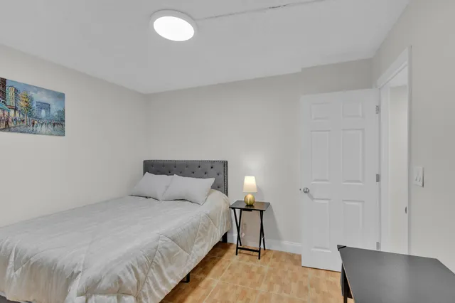 a bedroom with a bed and a lamp on the table