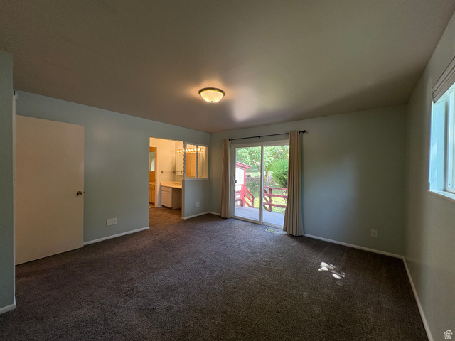 595 Meadowlark Road Orem, UT 84097 - Photo 35 of 87 Carpeted interior space featuring a sliding glass door, a single window, and a built-in vanity area with multiple light fixtures
