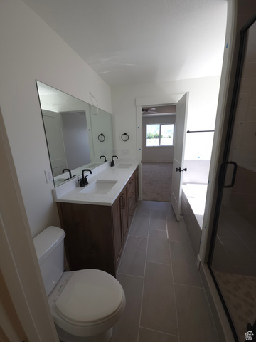 1267 West 2350 South Perry, UT 84302 - Photo 13 of 20 Bathroom featuring a dual vanity with a white countertop and rectangular sinks, dark wood-finish cabinetry, and matte black fixtures
