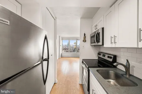 a kitchen with stainless steel appliances granite countertop a sink a stove and a refrigerator