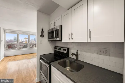 a kitchen with a sink a microwave and cabinets