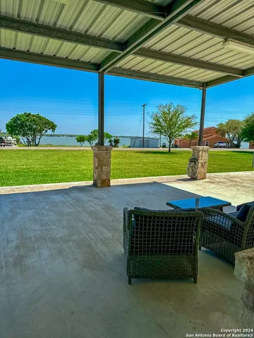 a view of a backyard with a table and chairs under an umbrella