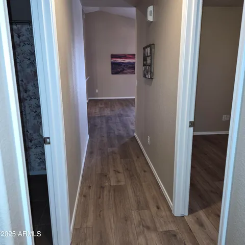 a view of a hallway with wooden floor and staircase
