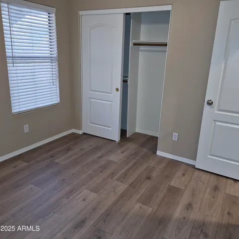 an empty room with wooden floor and closet