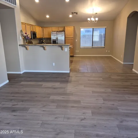 a view of kitchen with kitchen island wooden floor center island and stainless steel appliances