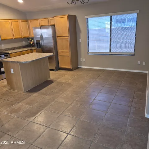 a kitchen with stainless steel appliances a stove a refrigerator a sink a counter top space and cabinets