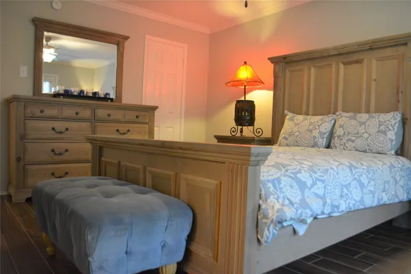a bedroom with a bed and a mirror on dresser